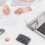 Persona con la nota simple del registro de la propiedad y otra documentación inmobiliario.