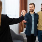 Agente inmobiliaria enseñando una vivienda alquilada a posibles compradores
