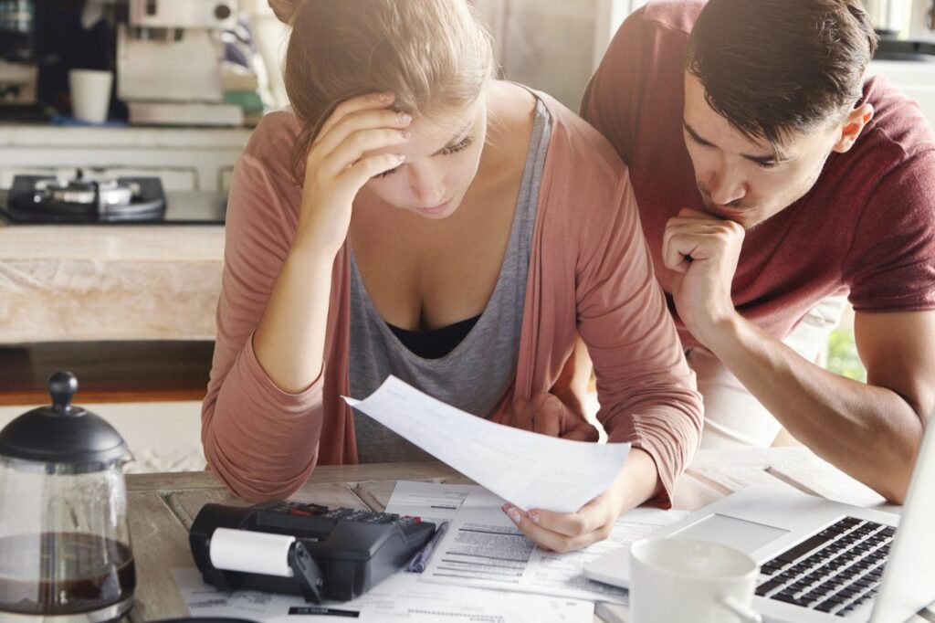 Gastos de compra de vivienda: ¿Cuánto deberías ahorrar antes de comprar? 1 Pareja calculando los gastos de compra de una vivienda